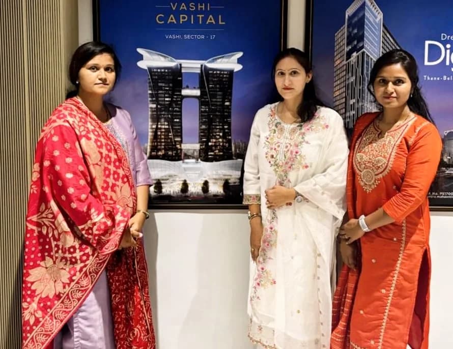 Three members of the Akewaar Marketing Services team standing beside project artwork
